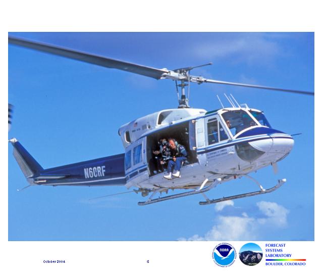 The image shows the author sitting with his feet dangling from the side of a helicaopter as he prepares to photograph a waterspout.