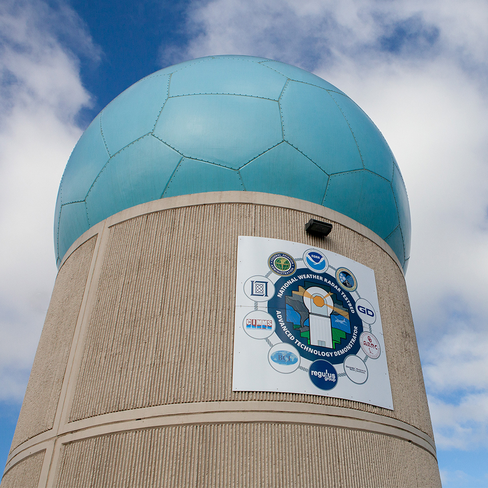 radar building with blue radome against a blue sky with clouds