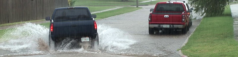 truck driving through street flooding