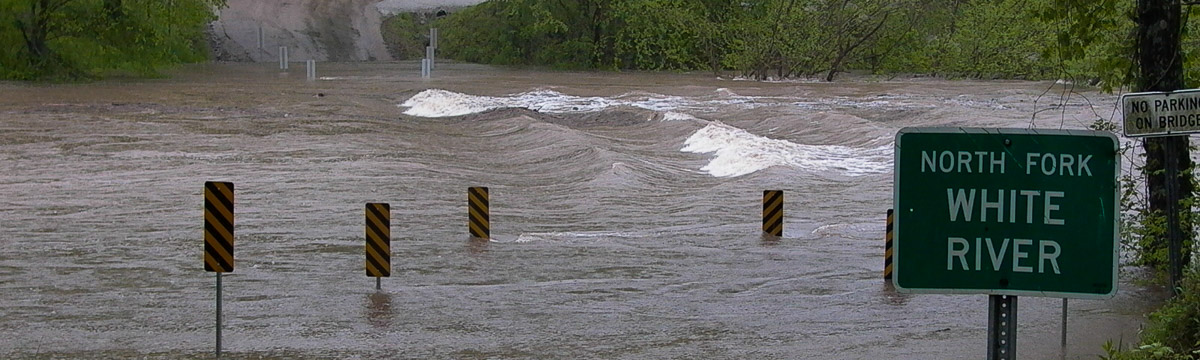 Flood waters rushing over road