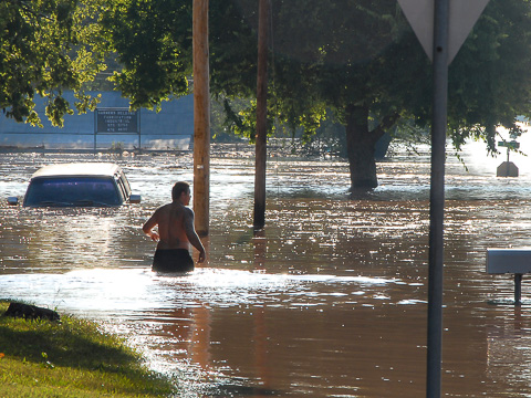 man wading through urban flooding